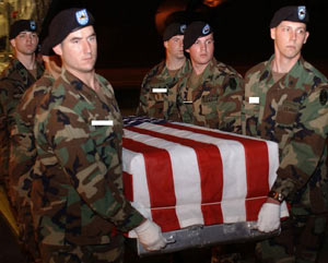 Soldier's flag-covered casket being loaded on to a plane for transport